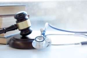 Gavel and stethoscope on a table, symbolizing the intersection of legal and medical fields.
