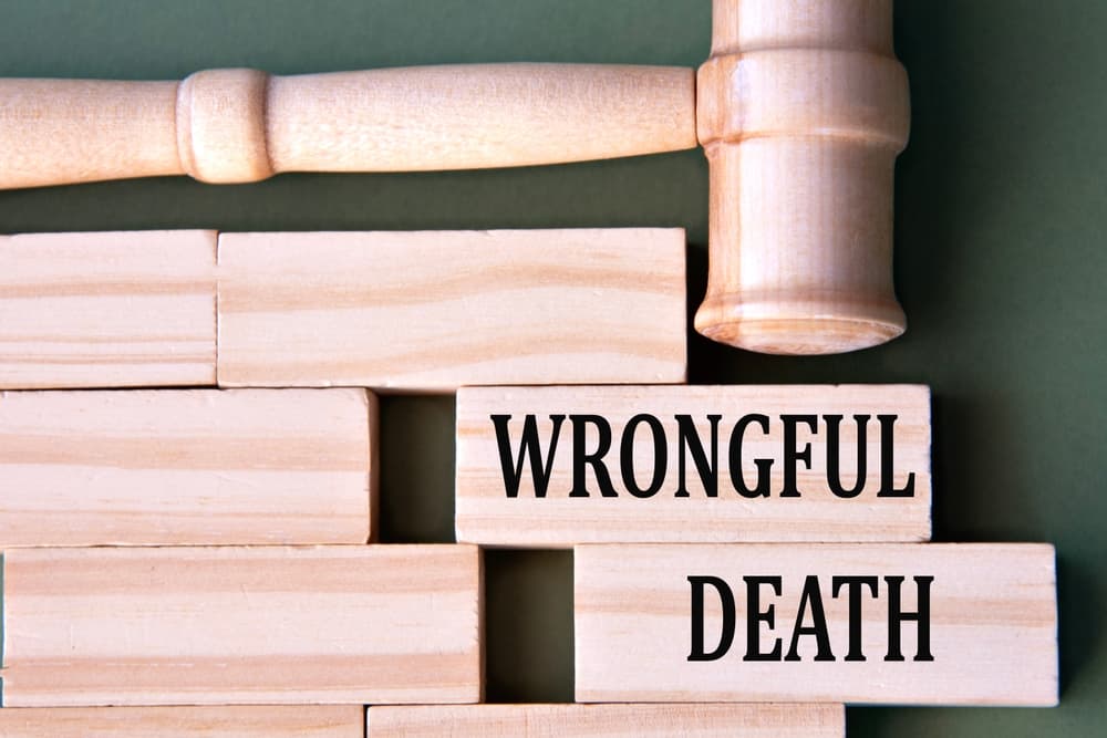 Wooden blocks spelling "WRONGFUL DEATH" under a judge's gavel, symbolizing legal proceedings.