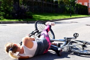 Woman fell off bicycle on road.