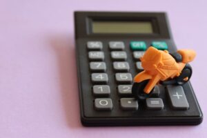 toy motorcycle and calculator on purple background