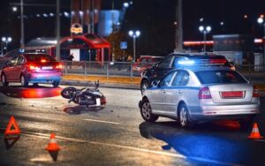 Motorcycle accident scene at night with police cars