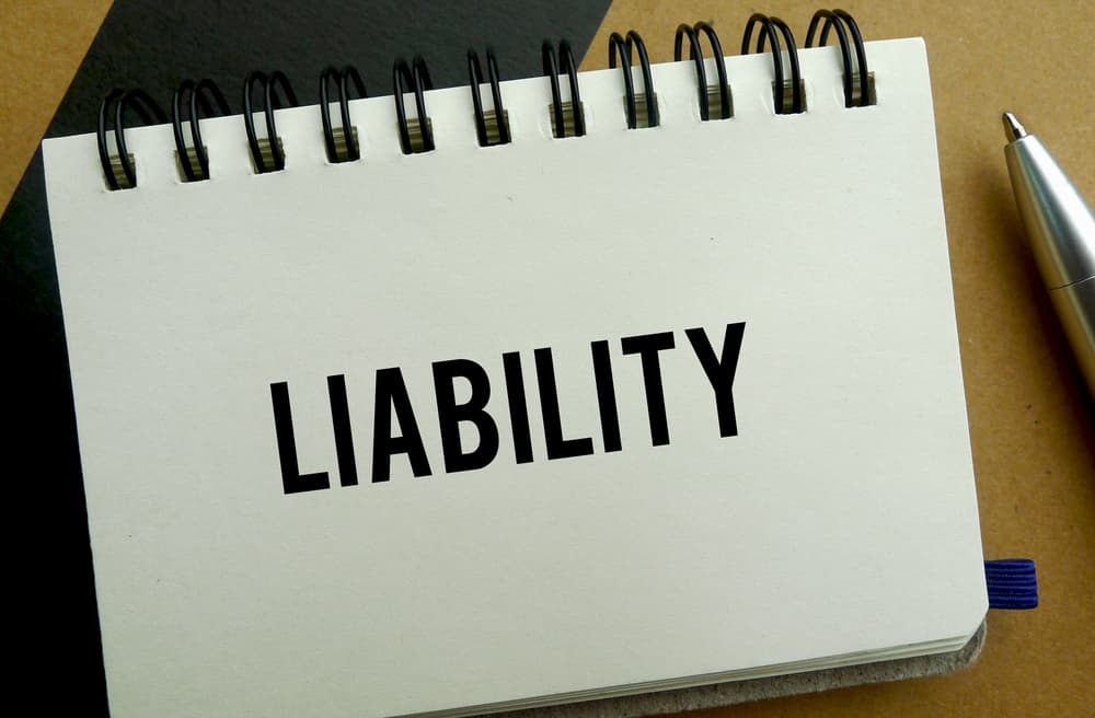 Liability memo written on a notebook with pen