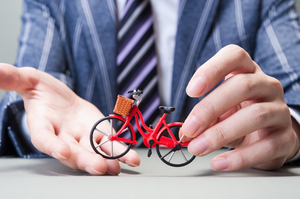 A Bicycle Accident lawyer holding a bicycle model in hands